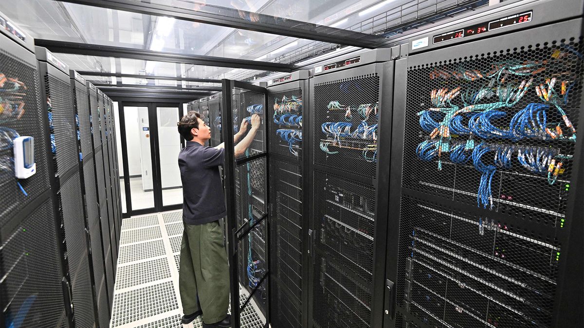 Data center worker in a server room working on racks.