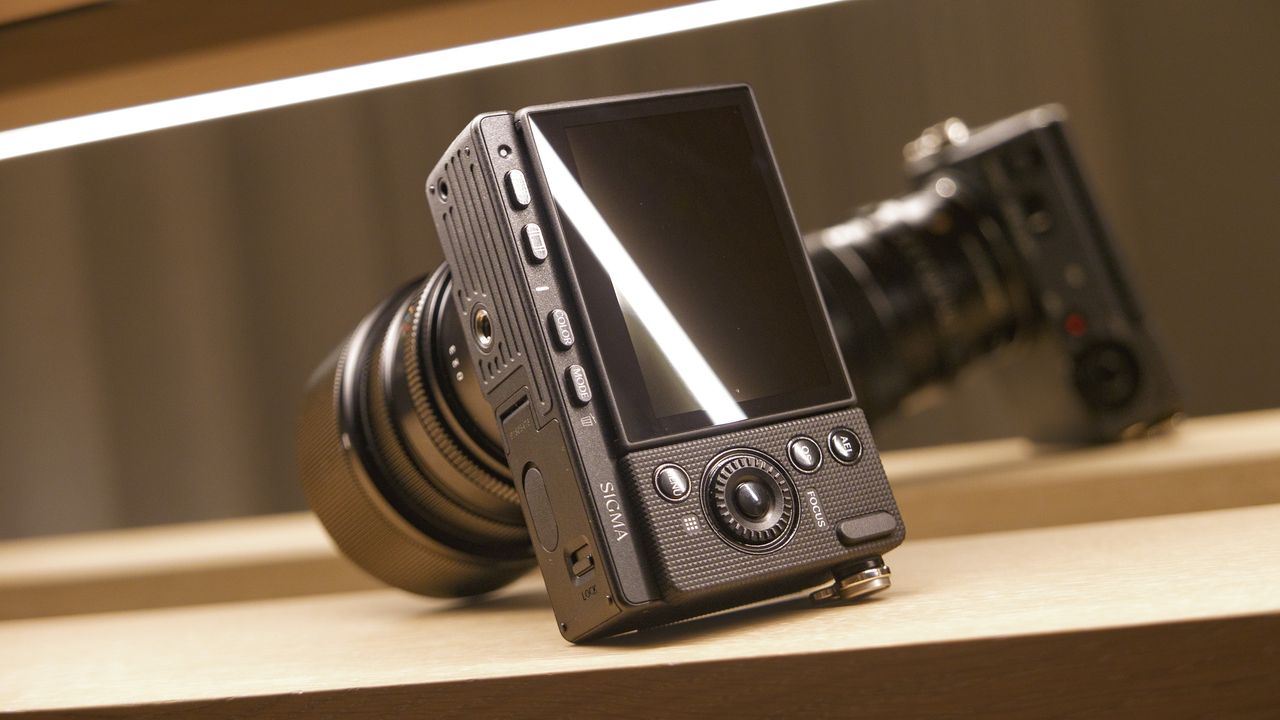 Sigma FP2 mirrorless camera with 50mm f/2 contemporary lenses attached, on a shelf, lit from above, view of its back
