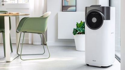The white AEG Comfort 6000 Portable Air Conditioner in a room with purple furnishings