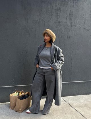 An influencer wears an all-gray outfit.