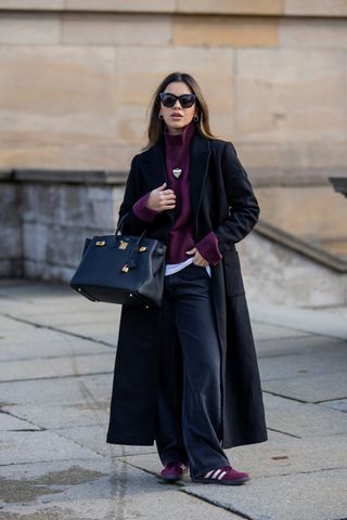 woman wearing turtleneck, coat, pants, and adidas sambas