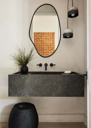 A simple bathroom with black marble and metal accents