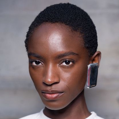 a beauty shot of a black model with glowy skin at Situationist catwalk show - lactic acid