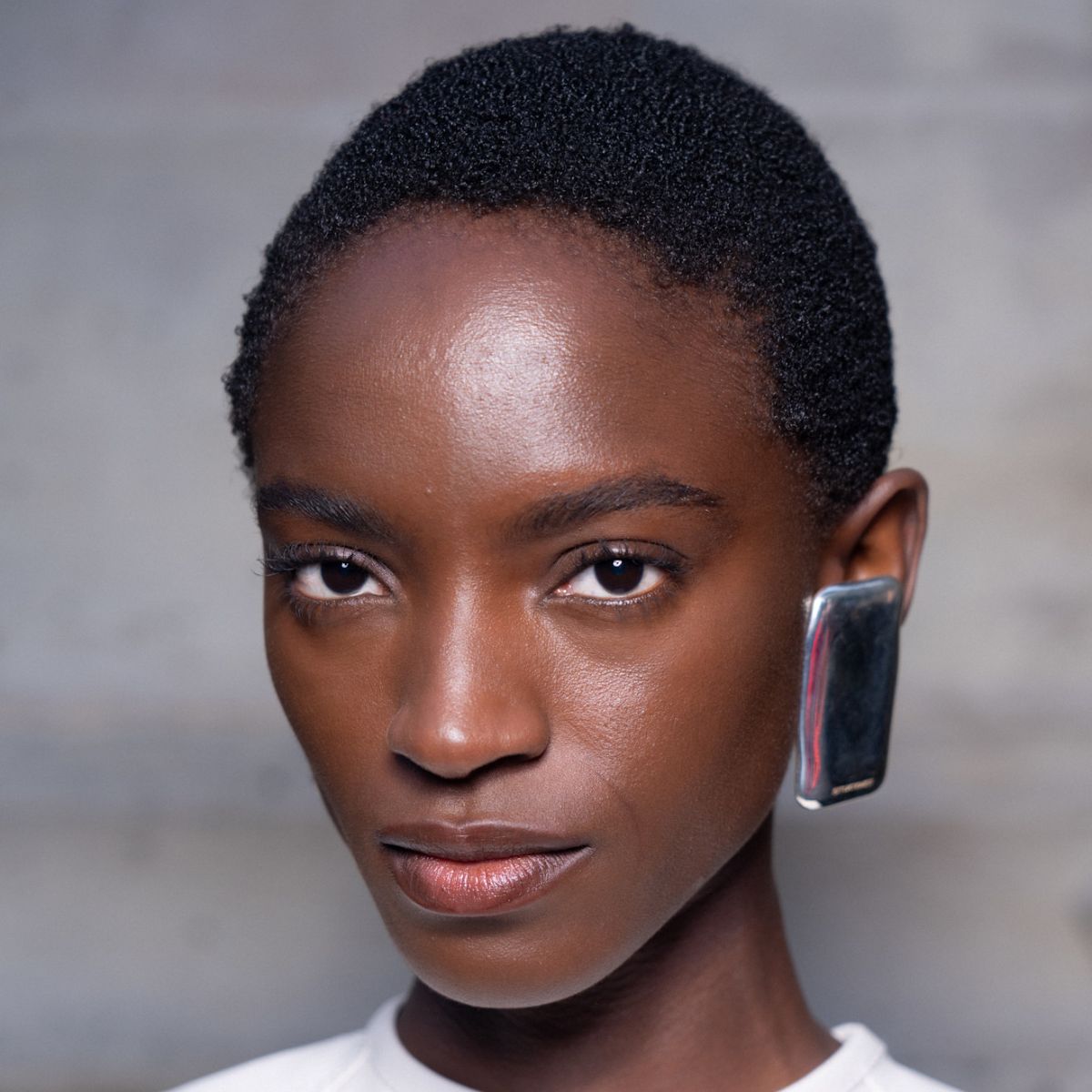 a beauty shot of a black model with glowy skin at Situationist catwalk show - lactic acid