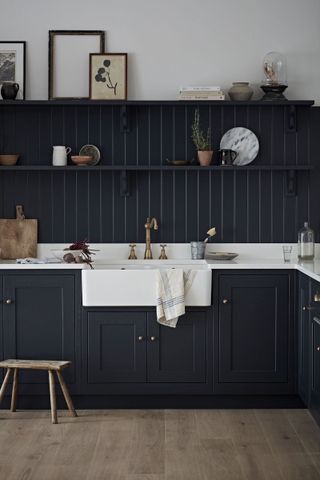 country kitchen with dark painted panelling around sink