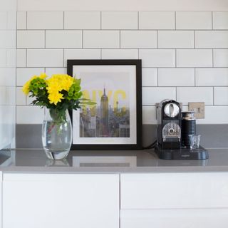 white wall with coffee machine and flower vase