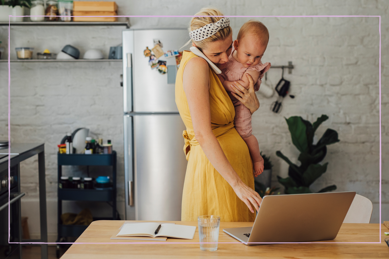 woman holding baby while working from home