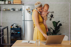 woman holding baby while working from home