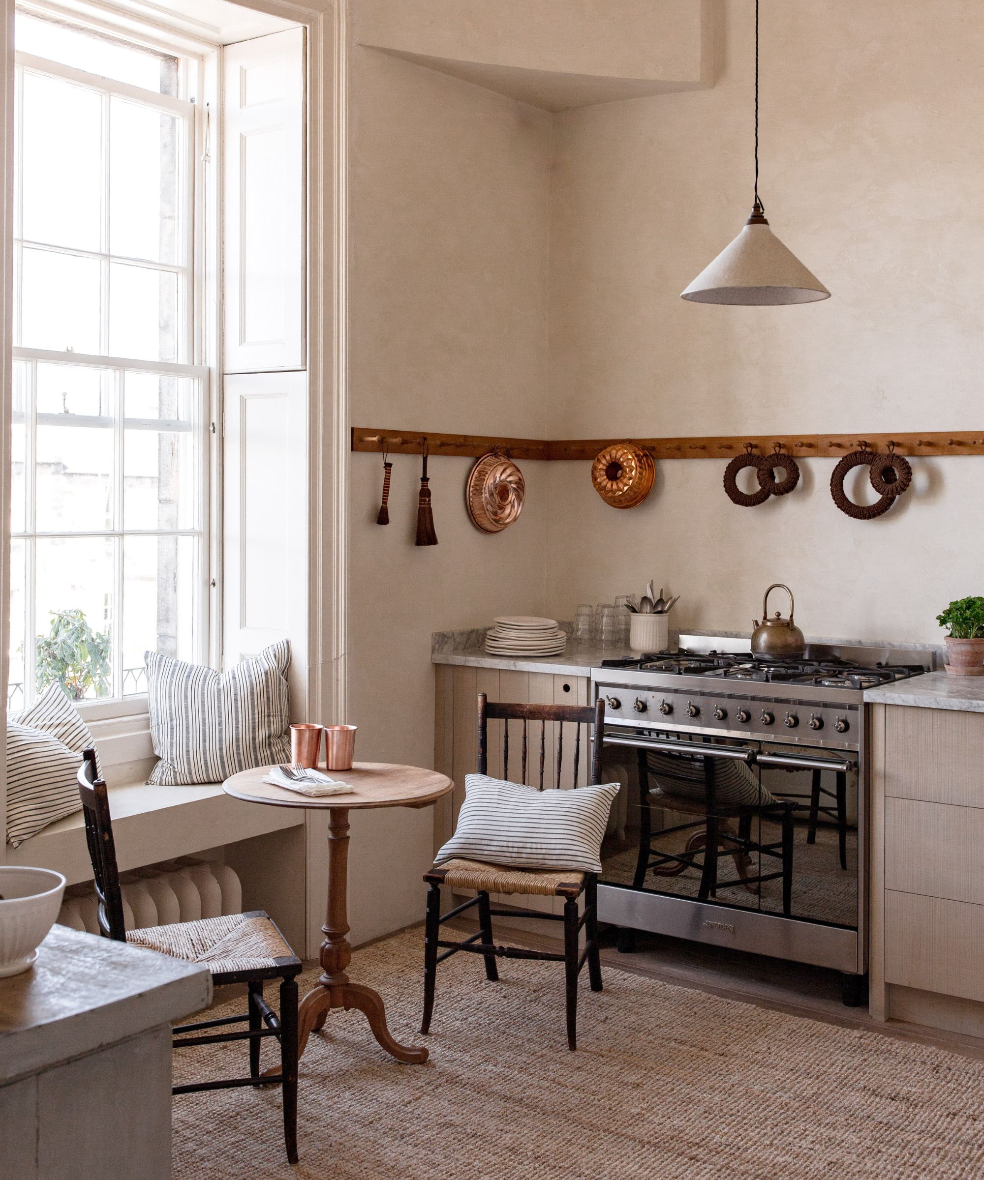 A vintage kitchen decorated with wall hooks holding antique copper molds