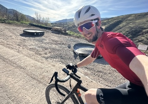 RIchards taking a selfie while riding on a dirt road in the hills
