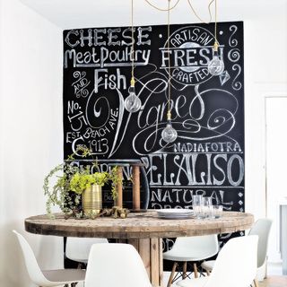 dinning table with chairs blackboard hanging bulb and potted plants