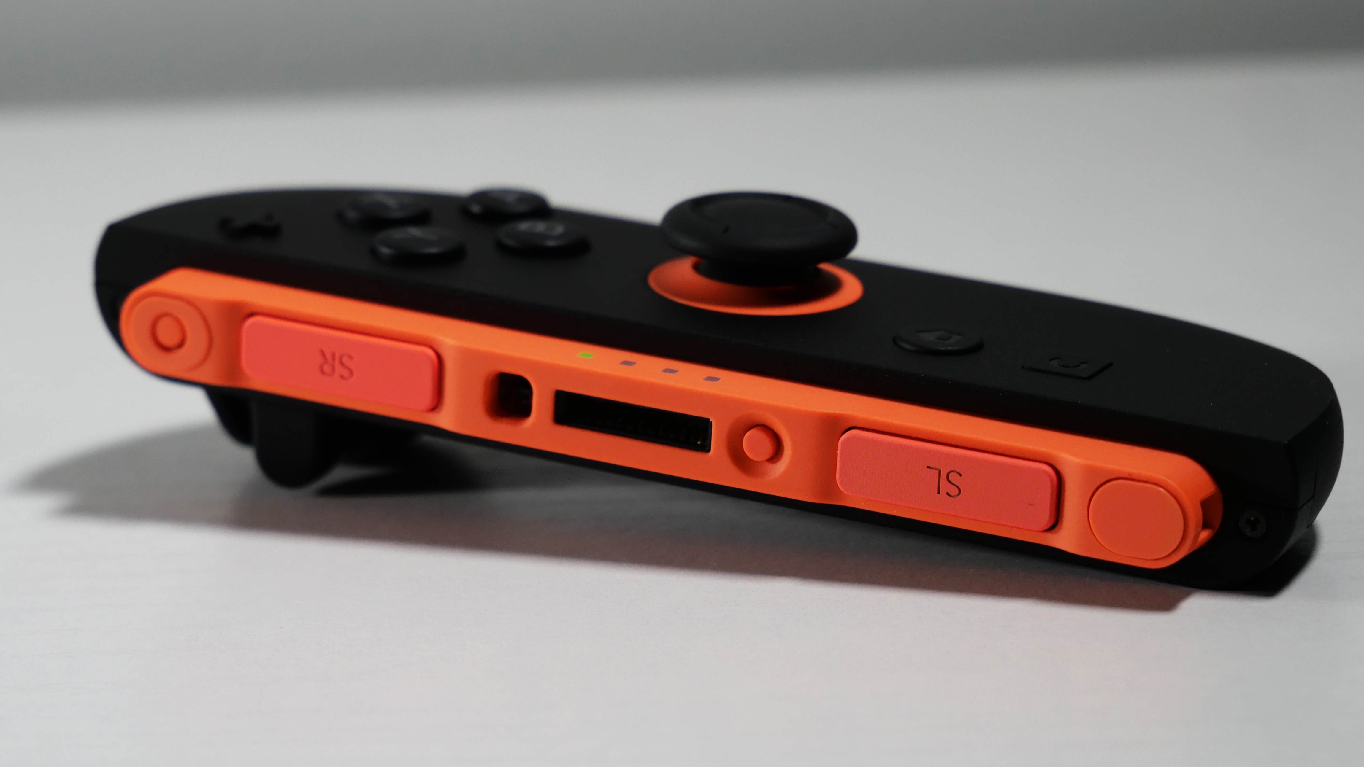 Nintendo Switch 2's Red Joy-Con 2 lying detached on a white desk.