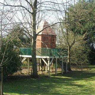 Childrens hexagonal treehouse in a garden on a raised platform