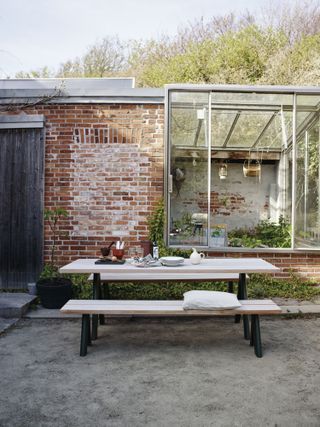 Outbuilding with glazed addition and dining set outside