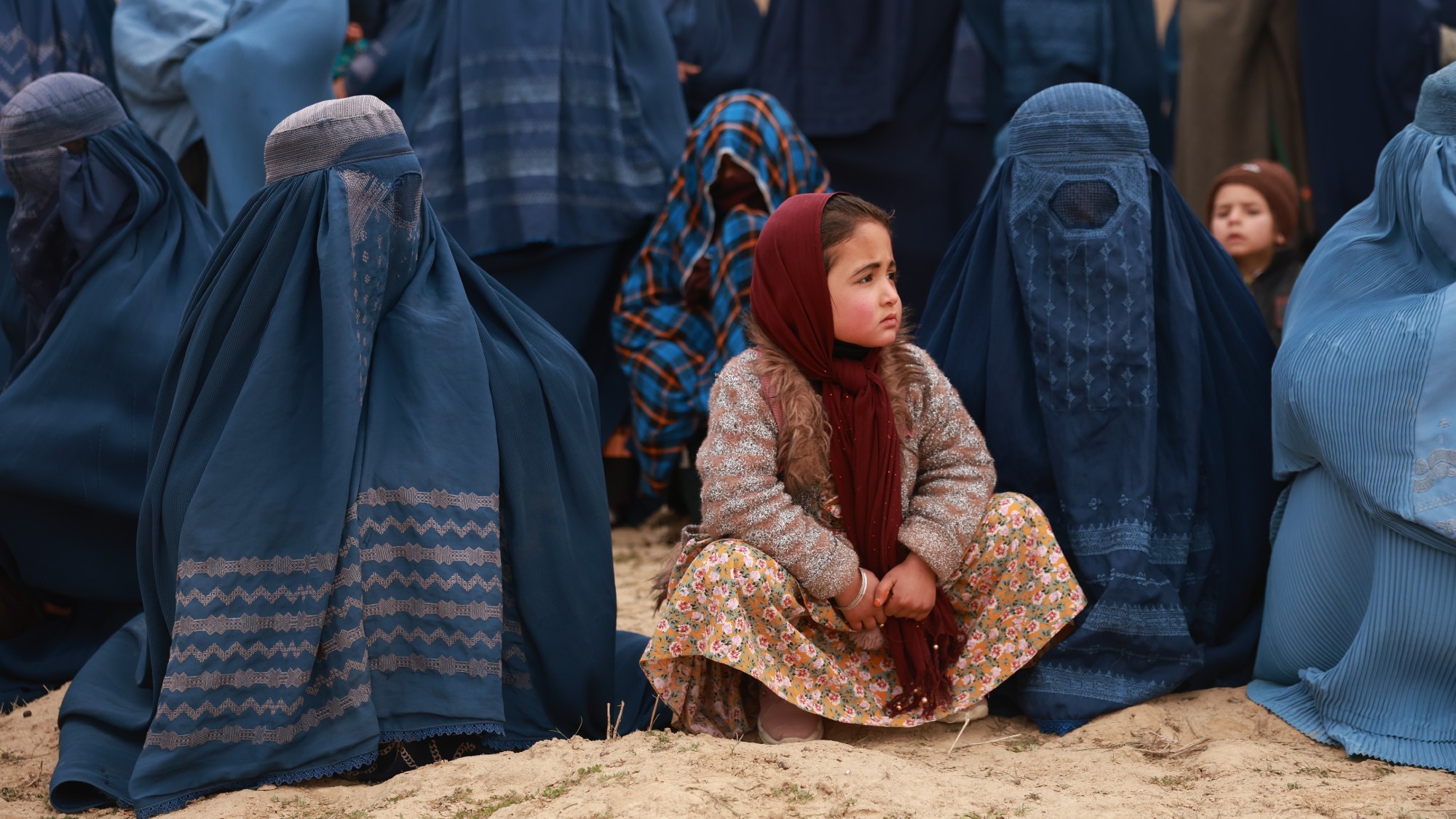 Afghan women in burqas, with a young girl in a headscarf