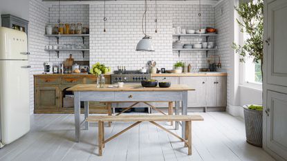 Rustic kitchen with distressed wooden cabinetry and metro tiled walls