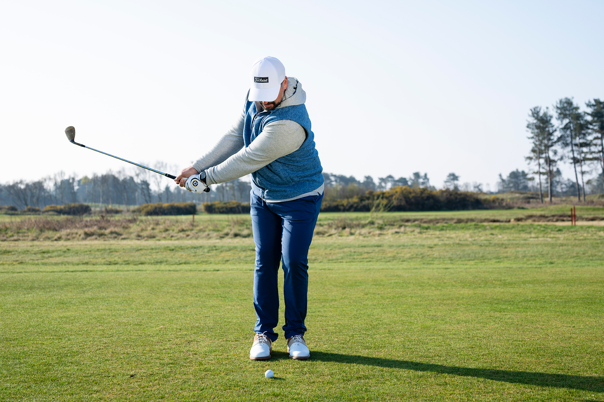 Peter Finch in the backswing of a high flighted lob chip shot, with ball position towards centre of stance and weight on lead side
