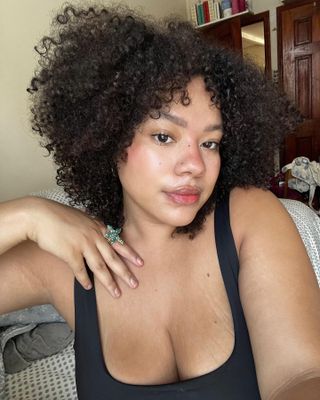 a woman taking a selfie with a curly, relaxed bob