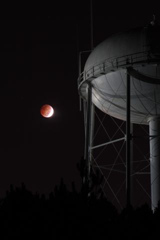 The full blood moon next to a water tower in Georgia