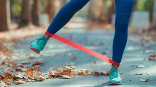 Woman Exercising Legs with resistance band outdoors