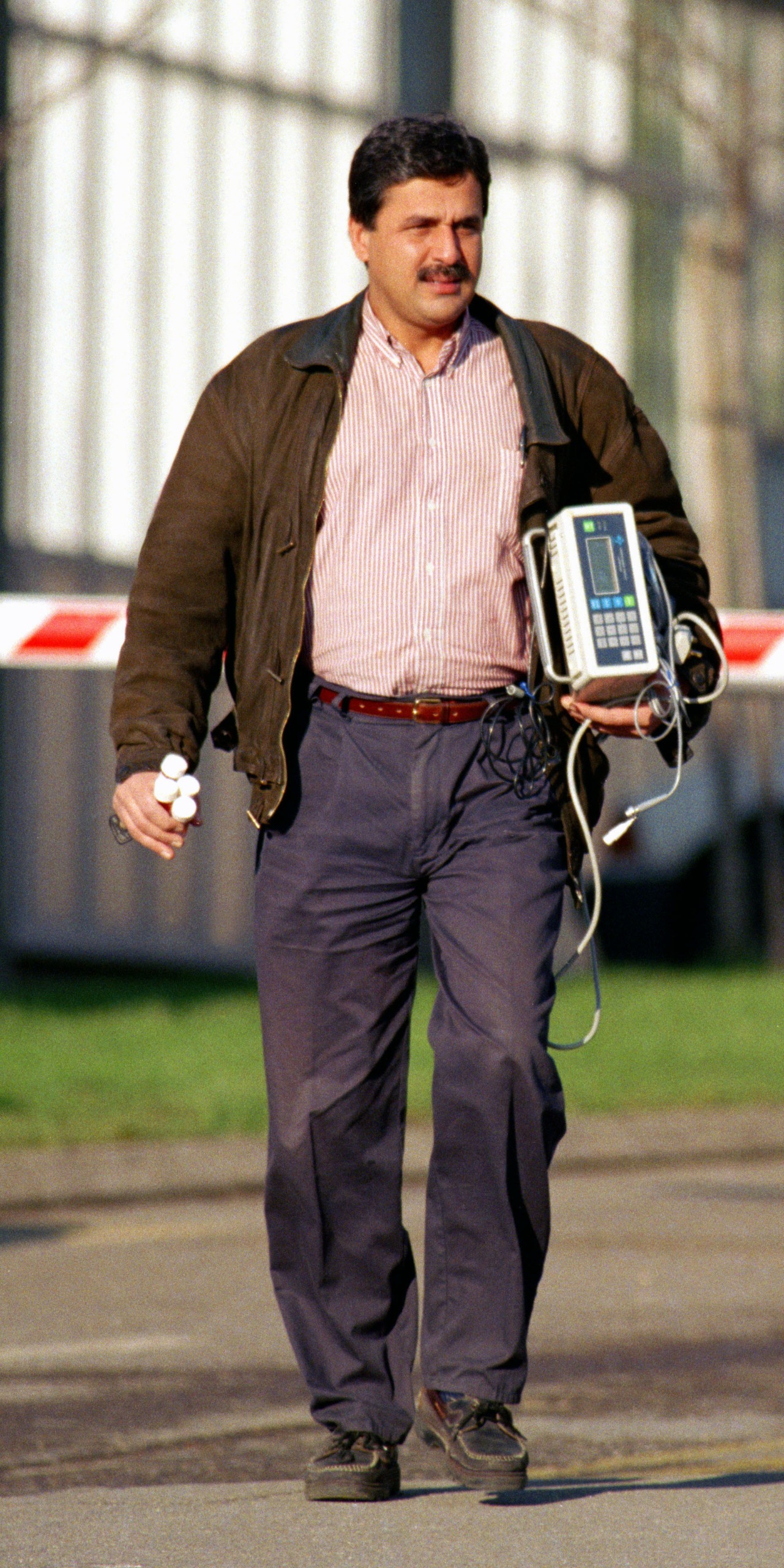 Hasnat Khan walking outside a hospital with medical equipment