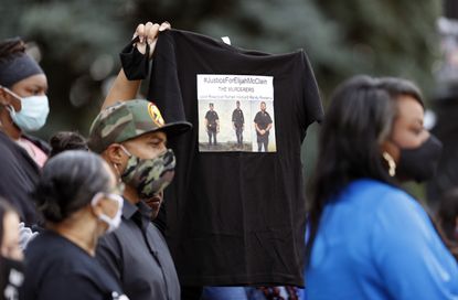A person holds up a shirt demanding justice for Elijah McClain.
