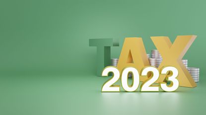 the word tax with coins against green background for tax changes