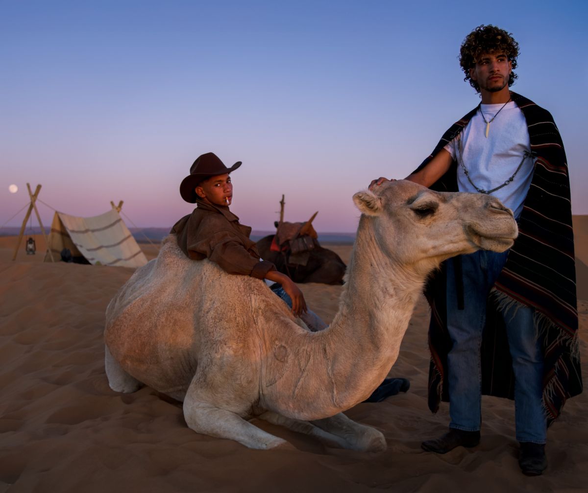 Men with camel in desert.