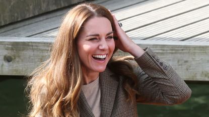 Kate Middleton smiling, running a hand through her hair