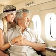 A couple looking out of the window of an airplane 