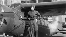 Amelia Earhart is seen with her airplane in a historic photo.