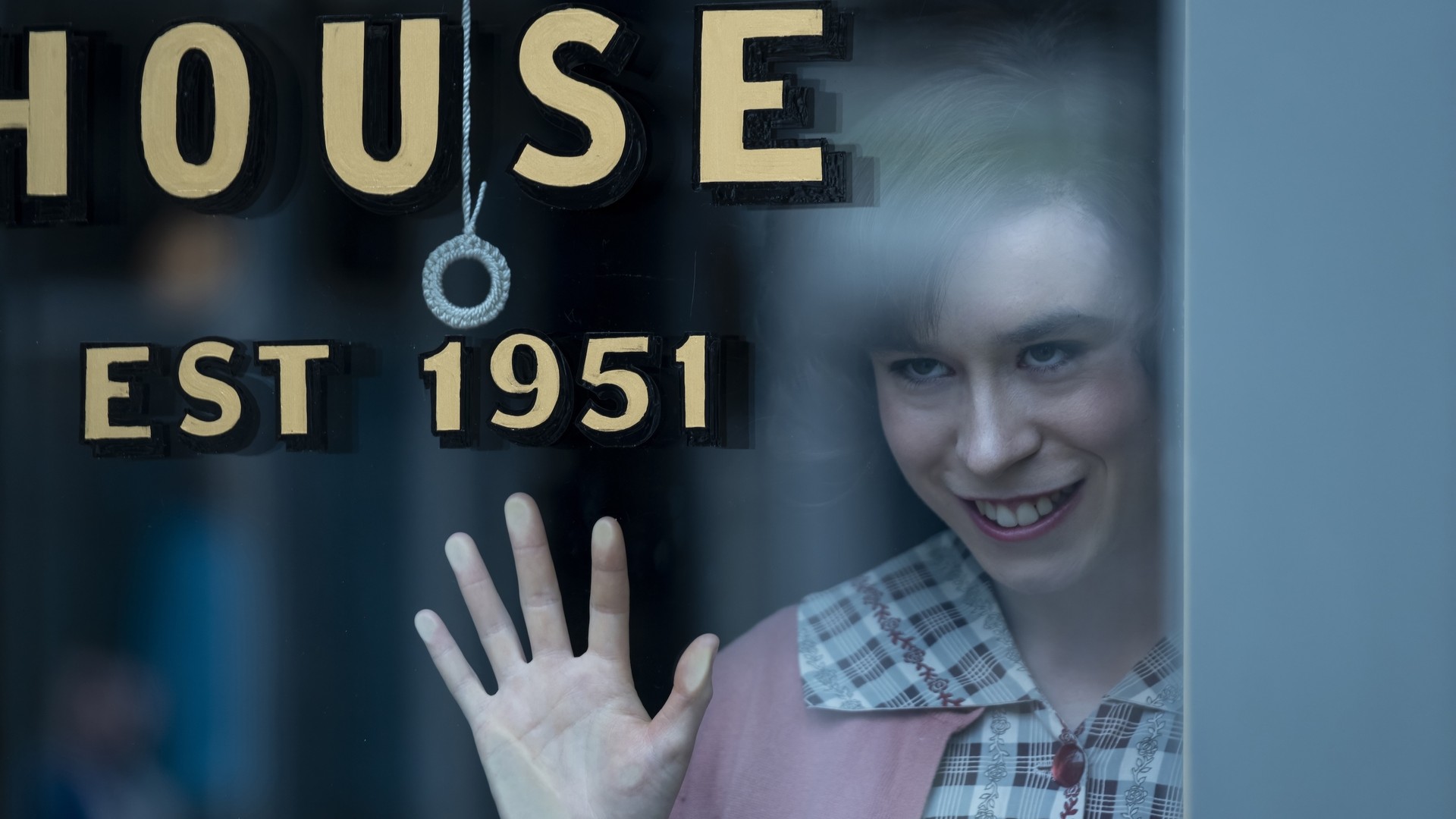 Promo image from IT: Welcome to Derry featuring a woman smiling through a window