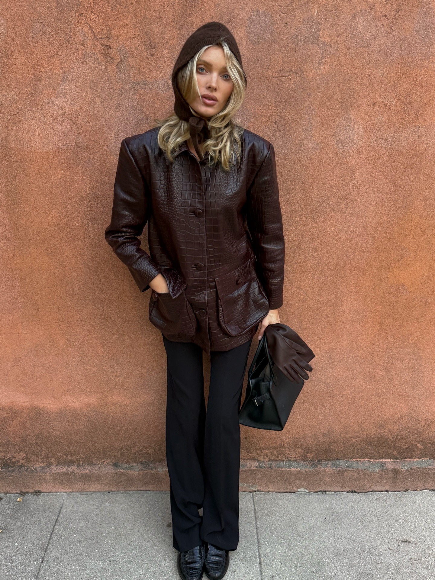 Elsa Hosk wearing a burgundy croc jacket with plane pants and flat loafers
