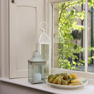 kitchen room with white window and plate with fruits