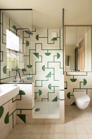 A bathroom with white and green tiles