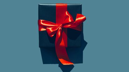 A present is wrapped up with a red bow.