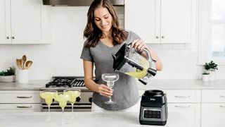 A woman making cocktails using a Ninja Professional Plus Blender with Auto-IQ