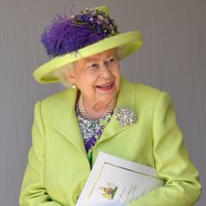 Queen Elizabeth in a green coat and green and purple hat