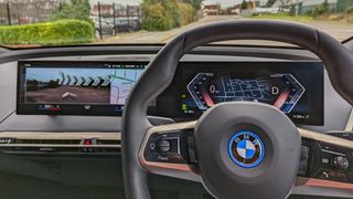 View from drivers seat of steering wheel and central display in the BMW iX