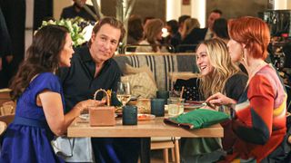 A scene from And Just Like That showing Aidan, Carrie, Miranda and Charlotte having lunch