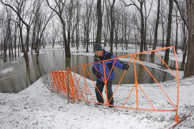 Workers remove the barricades from the flooded 'cross Worlds course