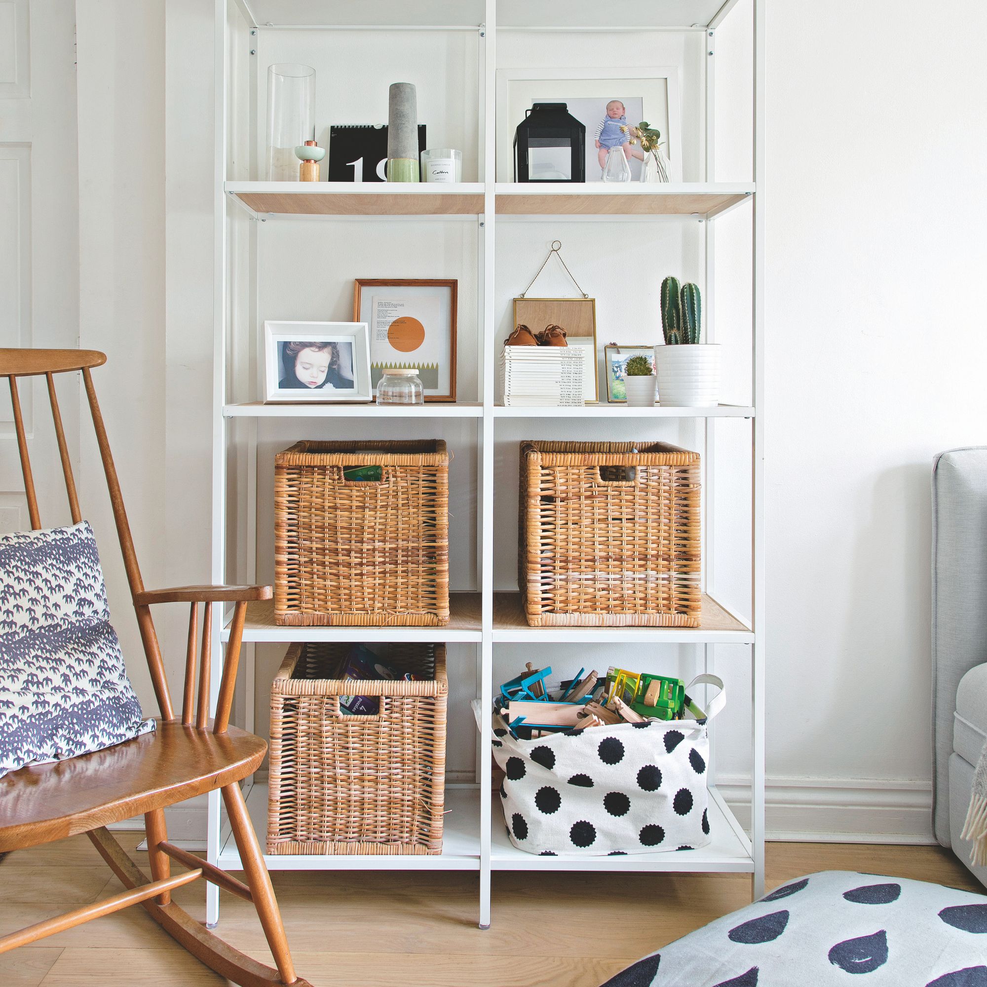 storage unit in a white living room, full of wicker storage baskets