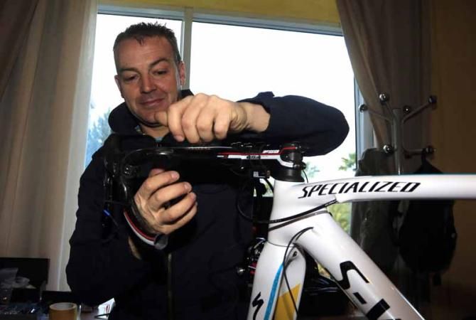 A mechanic gets to work on some last minute changes to a team bike