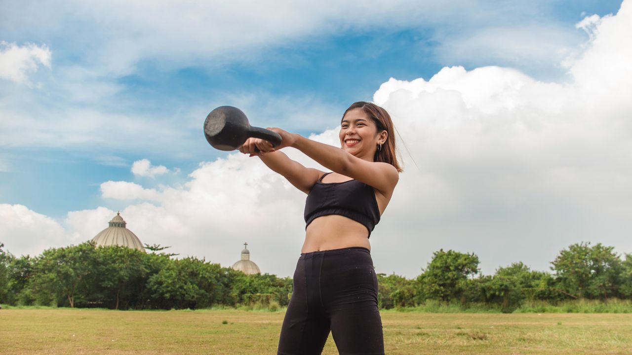 A woman performing a kettlebell swing 