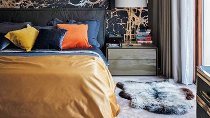 Bedroom with black and orange mural and grey carpet