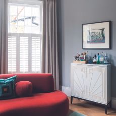 Grey living room with white cabinet and red sofa