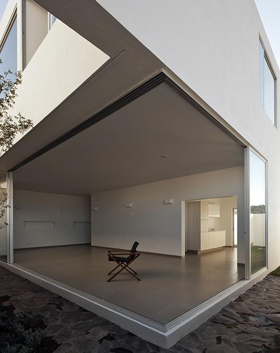 Grey wooden chair on balcony of white building