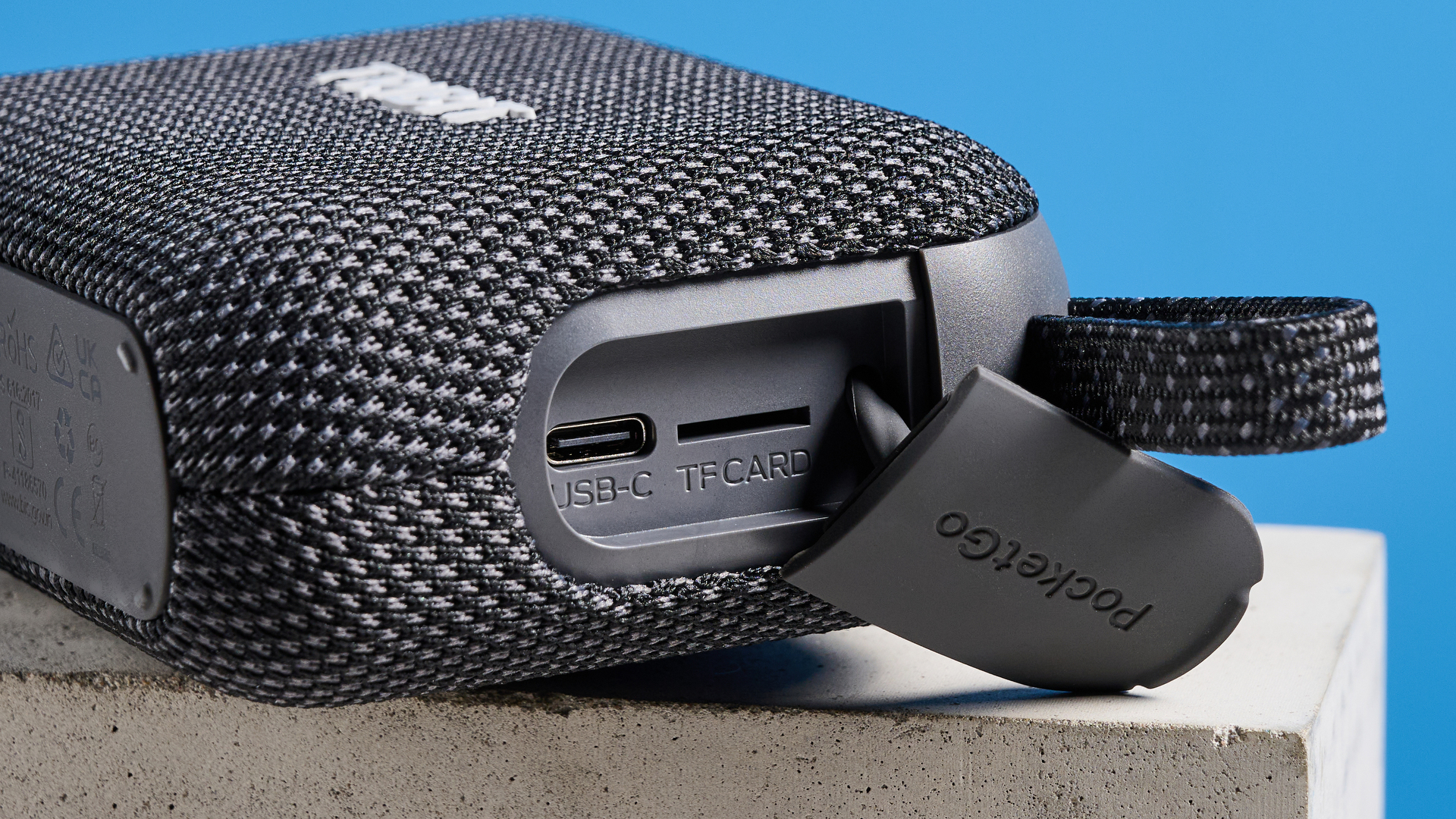 The Tribit PocketGo speaker in black photographed on a blue background.