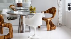 a chrome dining table with wood and tulip chairs