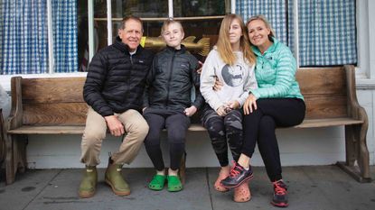 Aimee and Barrett Foster with son George and daughter Elizabeth sit on a bench for a photo in Cape Cod, Mass.